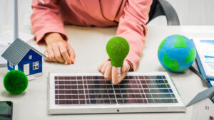 Female entrepreneur working at desk in clean energy sector Focusing on wind turbines solar energy Renewable energy Sustainable development goals House that uses solar energy and electric vehicles